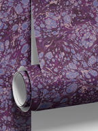 Roll detail of Milano Christina wallpaper by Ashley Woodson Bailey, an ornate marble in periwinkle and cornflower over deep plum, moody and a little mysterious.